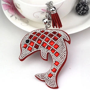 Close-up of red dolphin keychain featuring sparkling rhinestones, small bell and red tassel