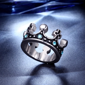 Detailed close-up of a silver crown ring with blue rhinestones and cross detail