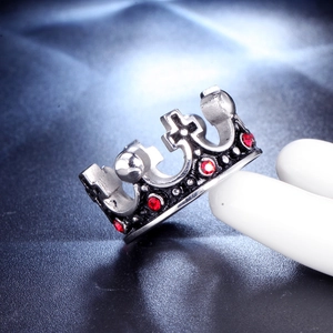 Macro shot of stainless steel crown ring featuring embedded red gemstones and dark metal