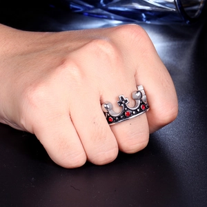 Macro shot of silver crown ring with red gemstones on a model hand