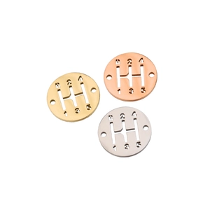 Detail of mirror polished 5-speed gear shift charms in gold, rose gold and silver