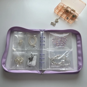 Detail view of purple jewelry organizer binder with transparent PE pouches and necklace storage