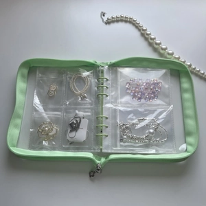 Detail of mint green jewelry binder with 6-grid transparent PVC zipper pockets