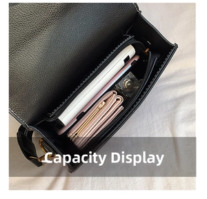 Interior view of black leather shoulder bag showing capacity for phone and wallet