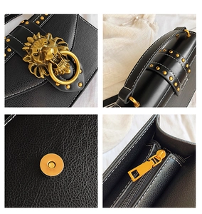 Detail of vintage black PU leather bag featuring gold lion head buckle and metal rivets