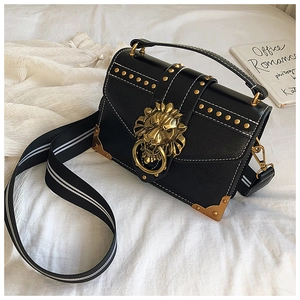 Close-up of black PU leather crossbody bag featuring gold lion head and rivet detail