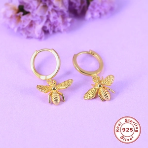 Macro shot of 925 sterling silver golden bee earrings with detailed texture