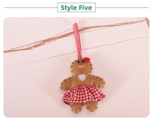 Close-up of felt gingerbread man Christmas ornament with red plaid skirt and flower detail