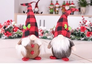 Close-up of two Christmas gnomes with red plaid hats and faux fur beards on a table