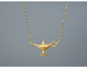 Detailed close-up of a golden Aladdin lamp pendant with brushed matte metal texture
