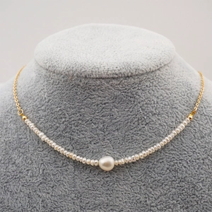 Elegant freshwater pearl smiley necklace with gold chain on a velvet neck display