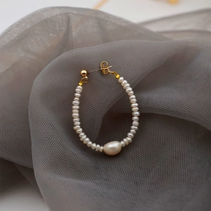 Hoop earring with freshwater pearls and a baroque pearl drop on elegant grey tulle fabric