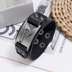 Close-up of wide black leather bracelet featuring a vintage Viking axe metal ornament