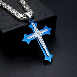 Detailed macro shot of silver stainless steel cross pendant with blue inlay and diamond accent