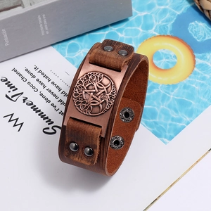Detailed view of vintage wide leather bracelet with Celtic knot emblem and metal rivets