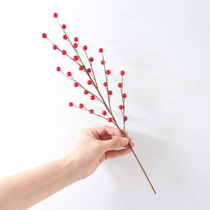 Close-up of artificial red berry stem with lifelike wood texture for home decor