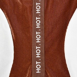 Détail d'une combinaison en velours avec tricot côtelé marron et blanc et sangle HOT