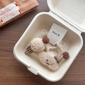 Close-up of cute plush ice cream and smiley cloud hair ties in a gift box