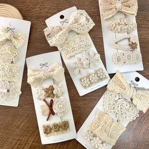 5-piece set of beige lace bow hair clips for girls on display cards with wooden background