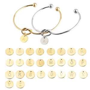 Polished stainless steel open bangle with initial heart charm in gold and silver finish