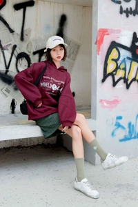 Close-up of vintage Harley-Davidson world tour print on burgundy oversized hoodie