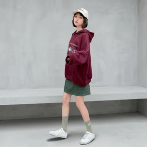 Street style girl in burgundy hoodie with Harley-Davidson logo and green plaid skirt