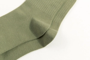 Detailed macro view of green knit sock heel texture and premium woven stitching