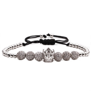 Détail du bracelet tressé noir réglable avec breloque couronne argentée et perles pavées