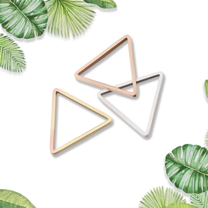 Polished triangle metal bangles in rose gold, silver, and gold on palm leaf decor