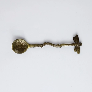 Detail of dragonfly branch handle spoon with hammer texture in vintage brass finish