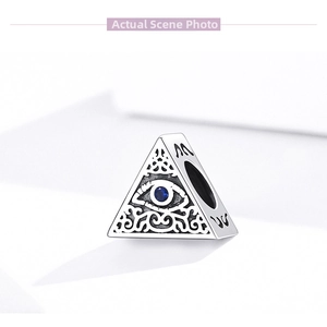 Detailed macro view of S925 silver triangle bead with blue stone and Evil Eye motif