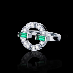 Detail view of silver ring with green emerald-cut stones and paved crystals