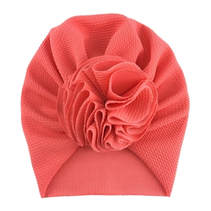 Detail of baby turban hat featuring waffle knit fabric and layered fabric flower