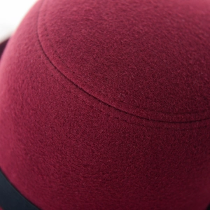 Gros plan sur un chapeau cloche en laine bordeaux avec d'élégantes surpiqûres doubles