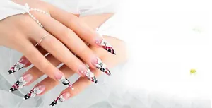 Detail view of 3D nail art with resin flowers and rhinestones using a drill pen