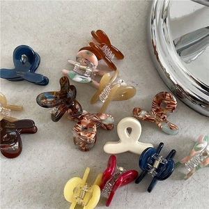 Chic acetate hair claws in various marble and tortoiseshell patterns for daily styling