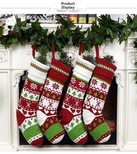 Set of four knitted Christmas stockings in red, white, and green hanging on a fireplace