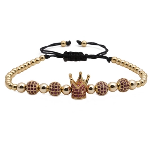 Detailed shot of crown charm bracelet with red stones and adjustable black braided cord