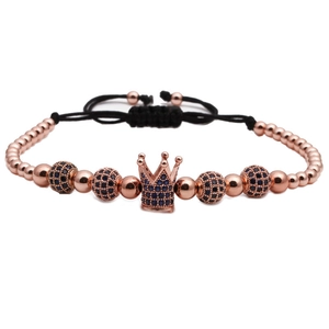 Detail of rose gold crown charm and blue zircon beads on an adjustable cord bracelet