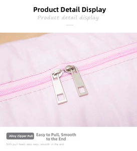 Detail of smooth pink double alloy zippers on durable foldable travel luggage bag