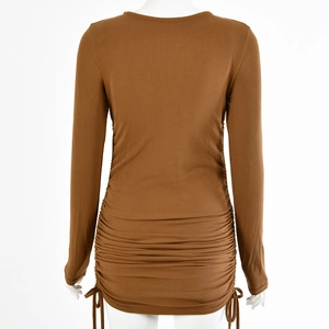 Detail of side drawstring ruching on a brown ribbed knit long sleeve dress