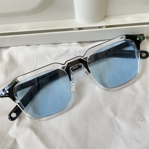 Polygonal cat-eye sunglasses with blue lenses and black transparent frames for women