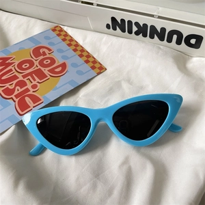 Detailed view of light blue cat-eye sunglasses with black lenses on white fabric