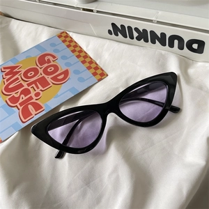 Detail of retro cat eye sunglasses with black frame and translucent purple lenses