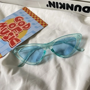 Detail view of light blue transparent cat-eye sunglasses with retro jelly-colored frames