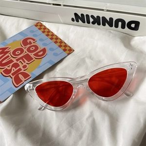 Detailed view of trendy transparent cat-eye sunglasses with vibrant red tinted lenses