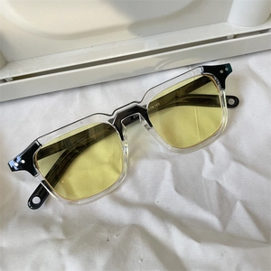 Macro detail of yellow tinted sunglasses showing size parameters on a bicolor frame