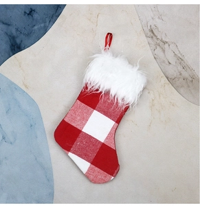 Detail of red and white plaid Christmas stocking with soft white plush cuff and loop
