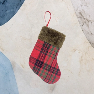 Classic plaid Christmas stocking with brown plush cuff and hanging loop on marble surface