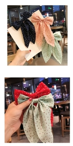 Detailed view of polka dot ribbon bow clips in navy, pink, red, and light green shades